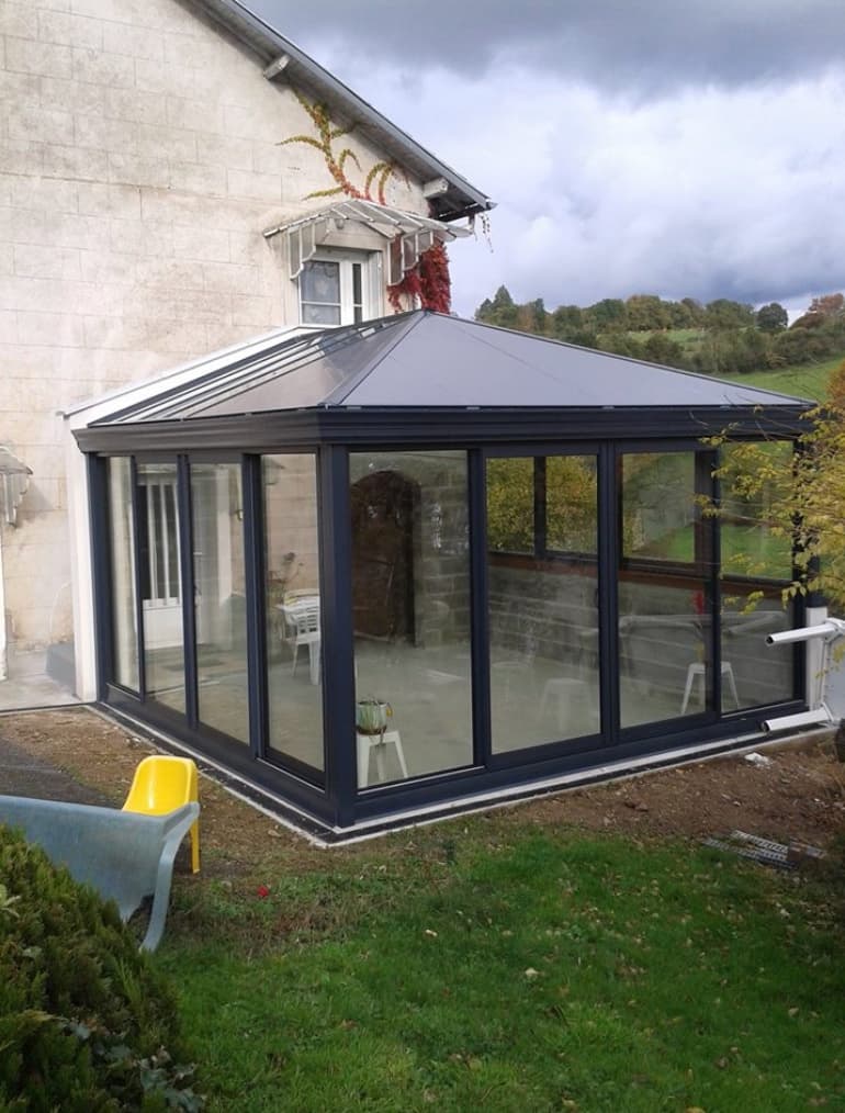 Véranda aluminium anthracite à toit quatre pans réalisée par SCAL en Haute-Vienne
